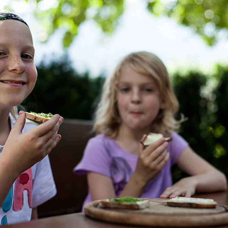 Mädchen genießen das frische Brot im Lesachtal