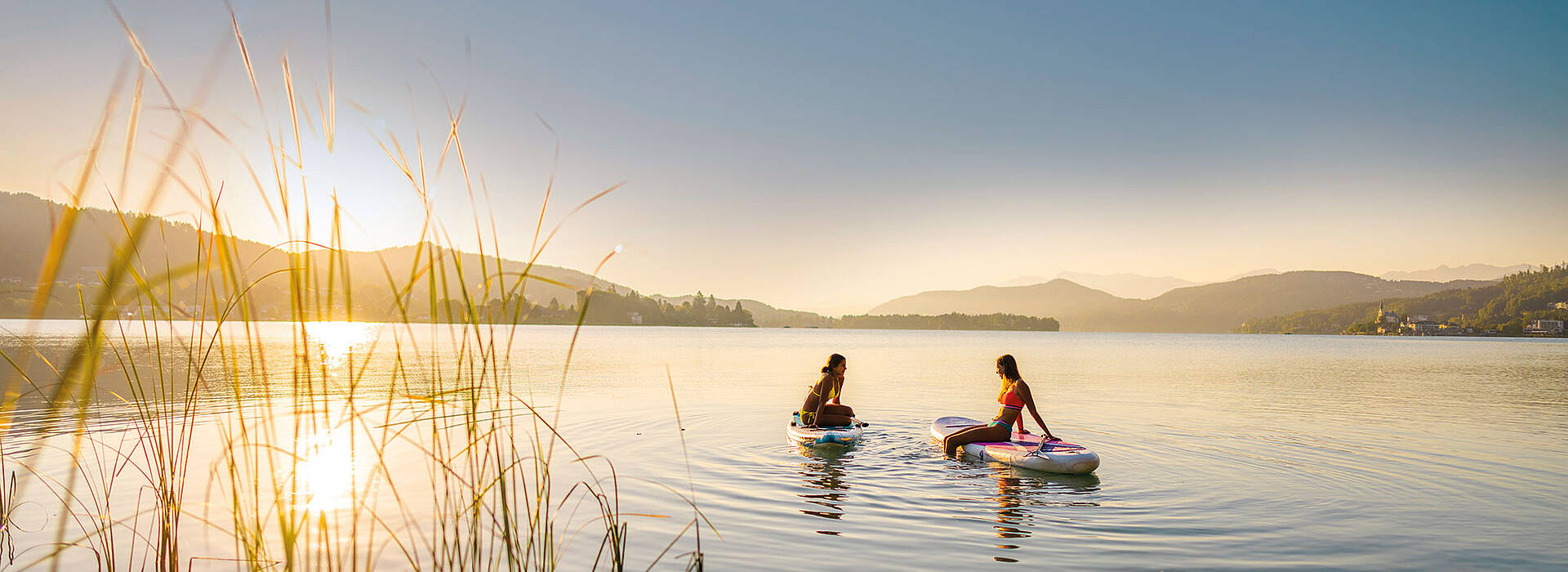 Zwei Damen am SUP am Woerthersee bei Sonnenuntergang