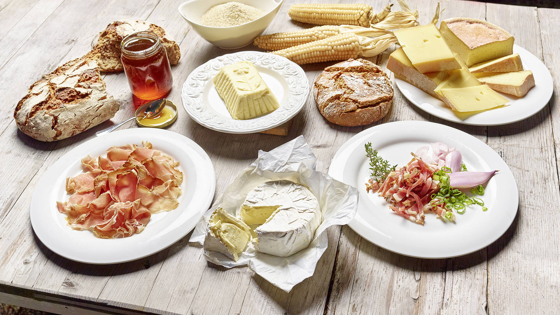 Slow Food in Kärnten am Holztisch mit Schinken Speck Käse Butter Honig