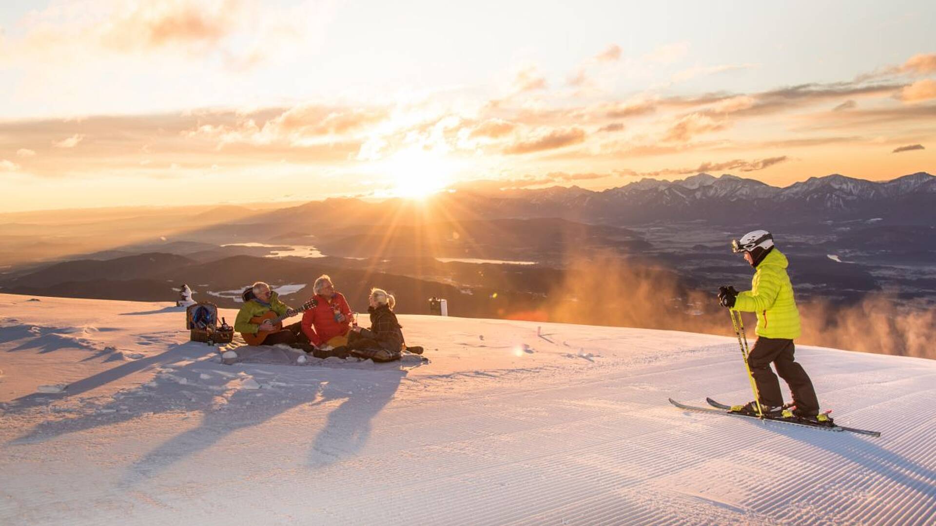 Mit Gitarre und Sekt den Sonnenuntergang auf der Piste bewundern. 